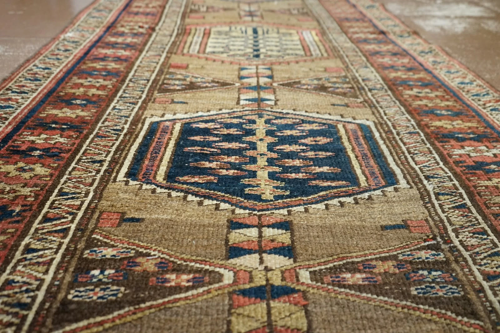 Vue rapprochée des fibres et motifs d’un tapis ancien