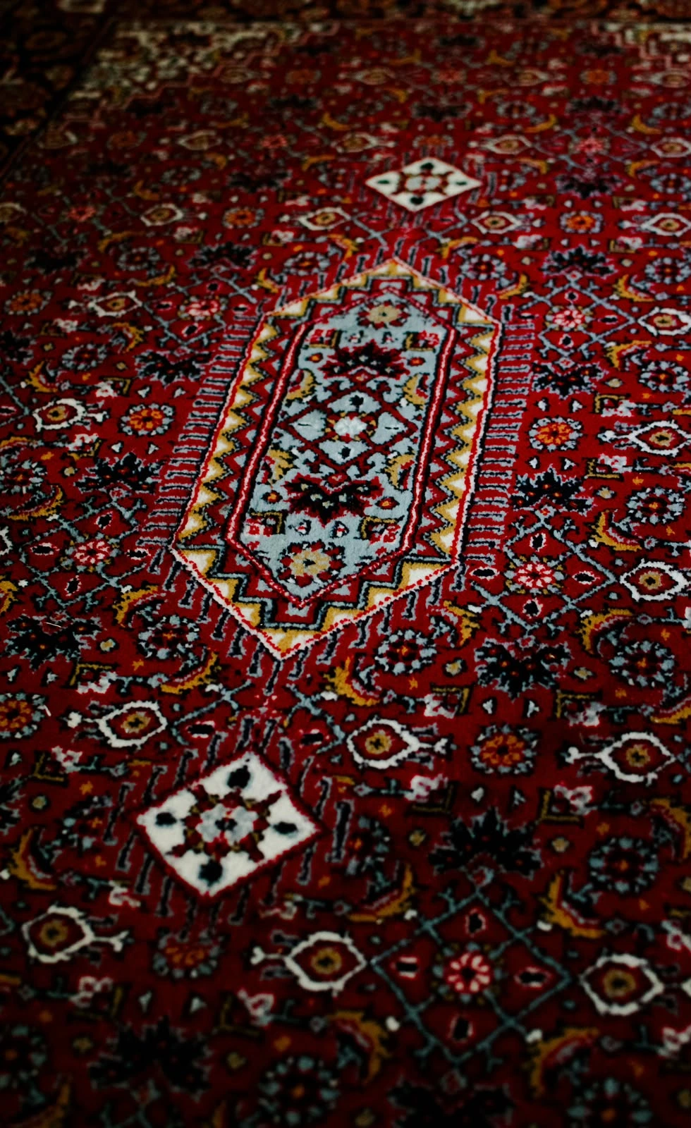 Détail de motifs rouges et bleus sur un tapis oriental